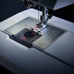 Sewing machine needle in action on a white surface Sewing machine needle in action on a white surface
