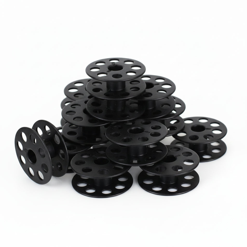 Multiple black spools stacked on a white background