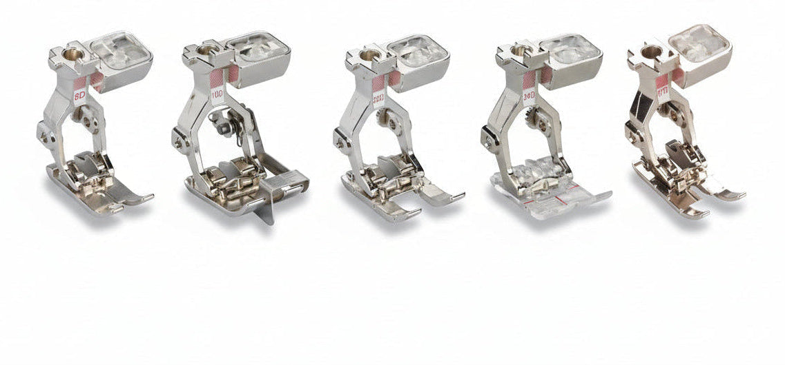 Set of five metal sewing machine presser feet on a white background